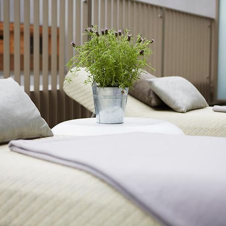 Steigenberger Hotel Am Kanzleramt Berlin Bilik gambar The photo shows two lounge chairs with soft, light-colored cushions. Between them, there is a small round table featuring a metal bucket filled with greenery. The setting appears to be designed for relaxation, with a clean and modern aesthetic, likel