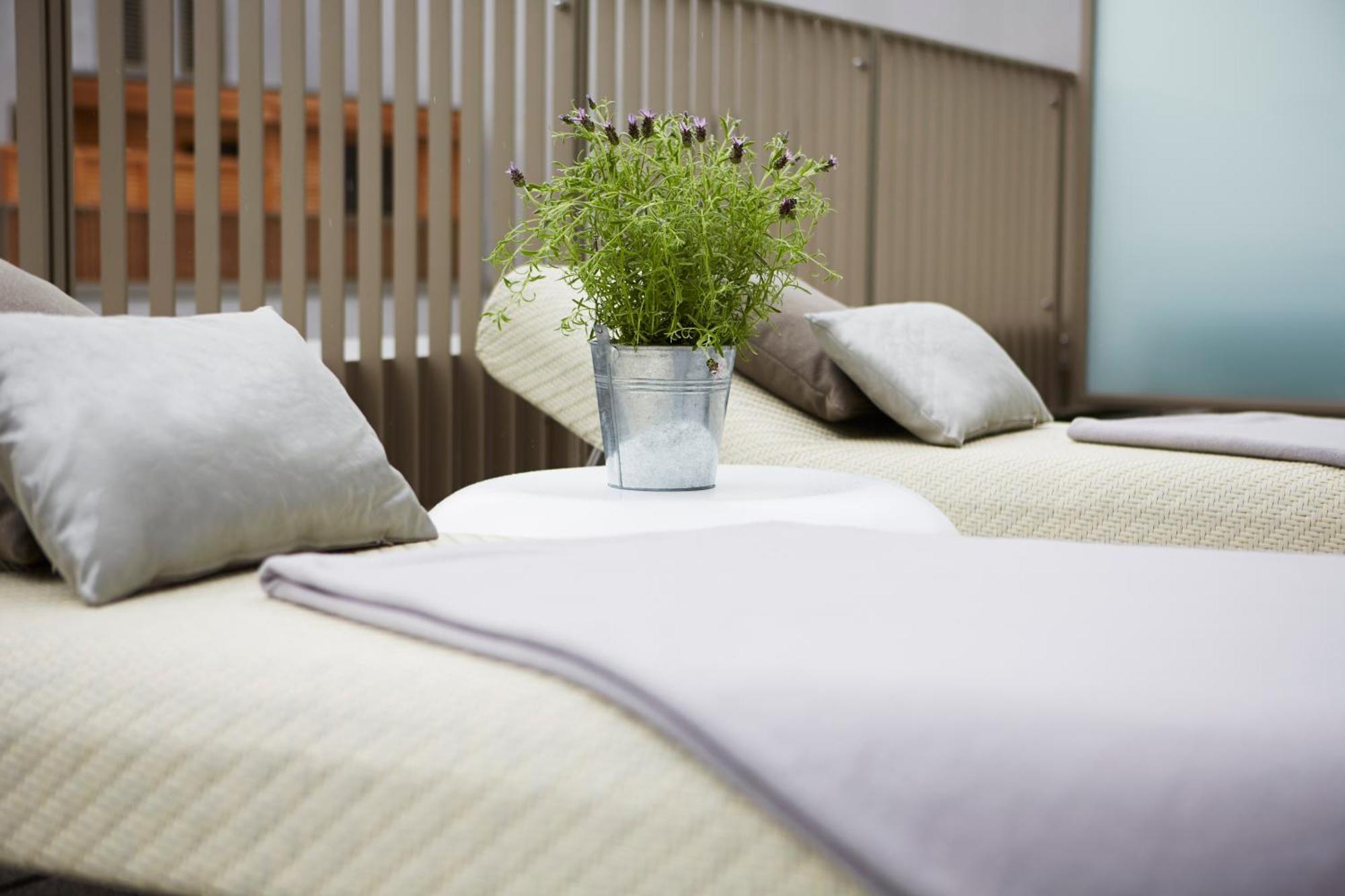 Steigenberger Hotel Am Kanzleramt Berlin Bilik gambar The photo shows two lounge chairs with soft, light-colored cushions. Between them, there is a small round table featuring a metal bucket filled with greenery. The setting appears to be designed for relaxation, with a clean and modern aesthetic, likel